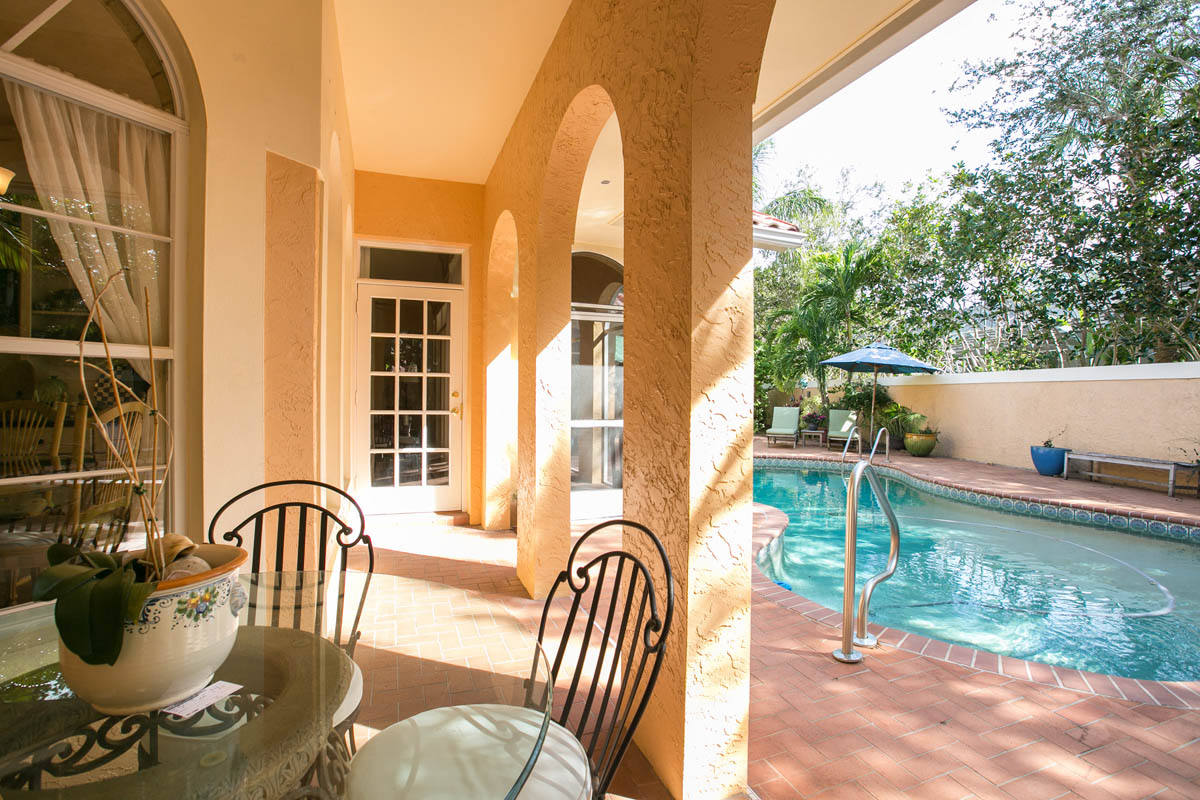 A covered portion of the back porch with pool views offers one of the many outdoor places for you and your guests to enjoy the outdoors.      