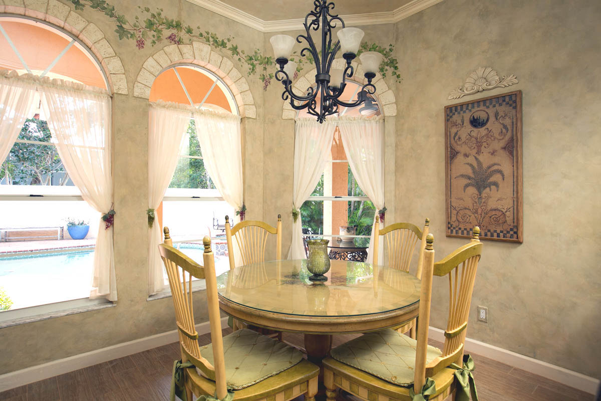 Breakfast nook with view pool views and details of the faux finished arches over the windows.                           