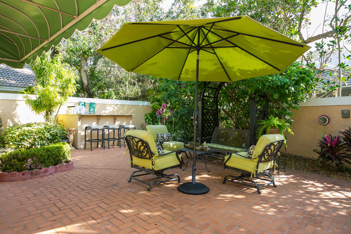 One of the many special areas in the back patio with a bougainvillea covered trellis and mature landscape invites casual gatherings.      