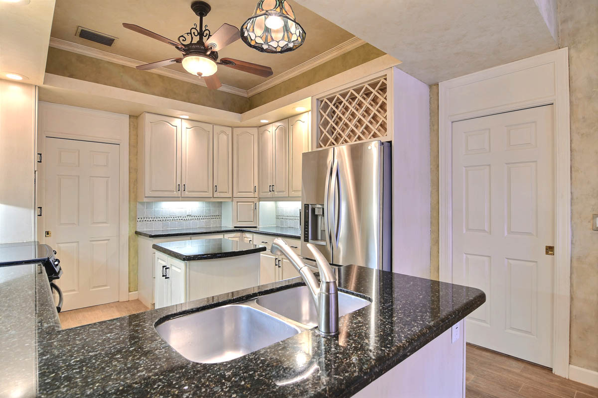 Kitchen with granite countertops, tray ceiling and crown molding and built-in wine rack.                    