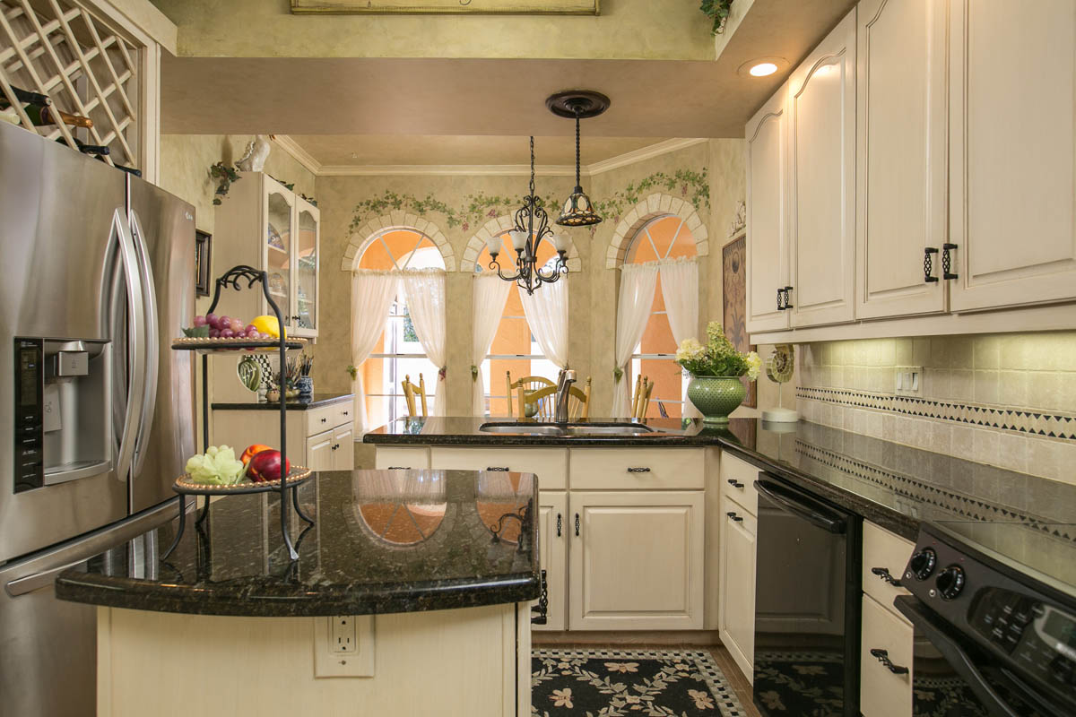 The well appointed kitchen features crown molding and granite countertops with an island.   