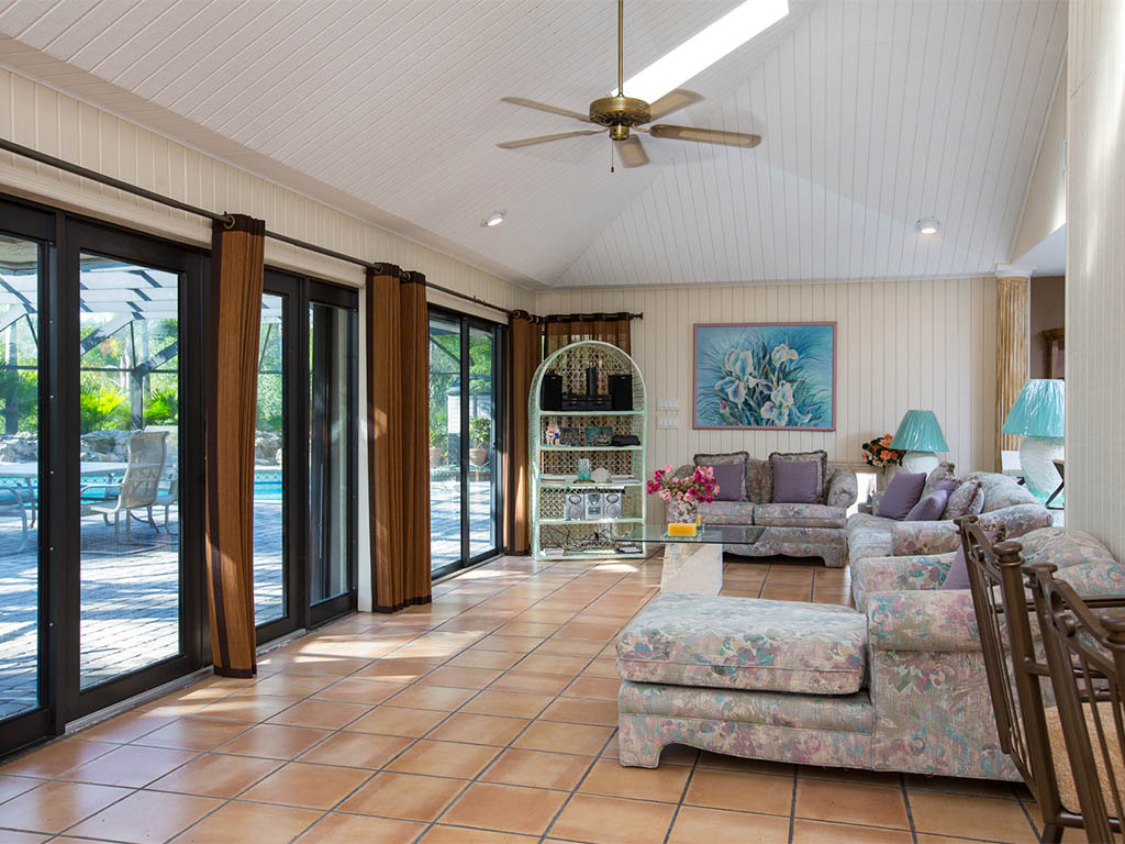 A view of the Living/Great Room of the Country Estate that opens up into the covered Lanai and Pool area 