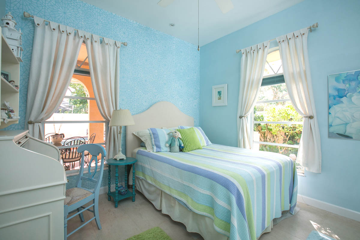 The second bedroom with stenciled accent wall with pool and garden views.                    