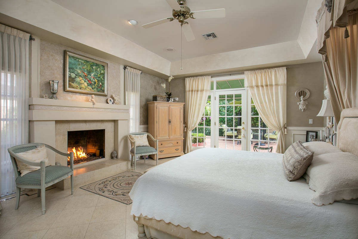 The elegant master suite features tray ceiling decorative painted walls, crown molding and a large fireplace and 2 walk-in custom designed California closets.  