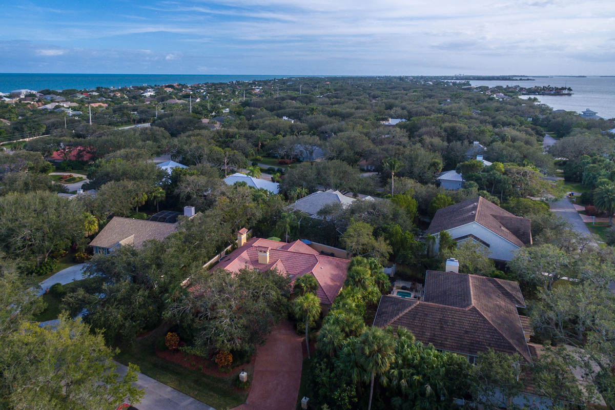 An aerial view of the house as it is located on the barrier island with short walk to the ocean on the left and Indian River lagoon on the right. 