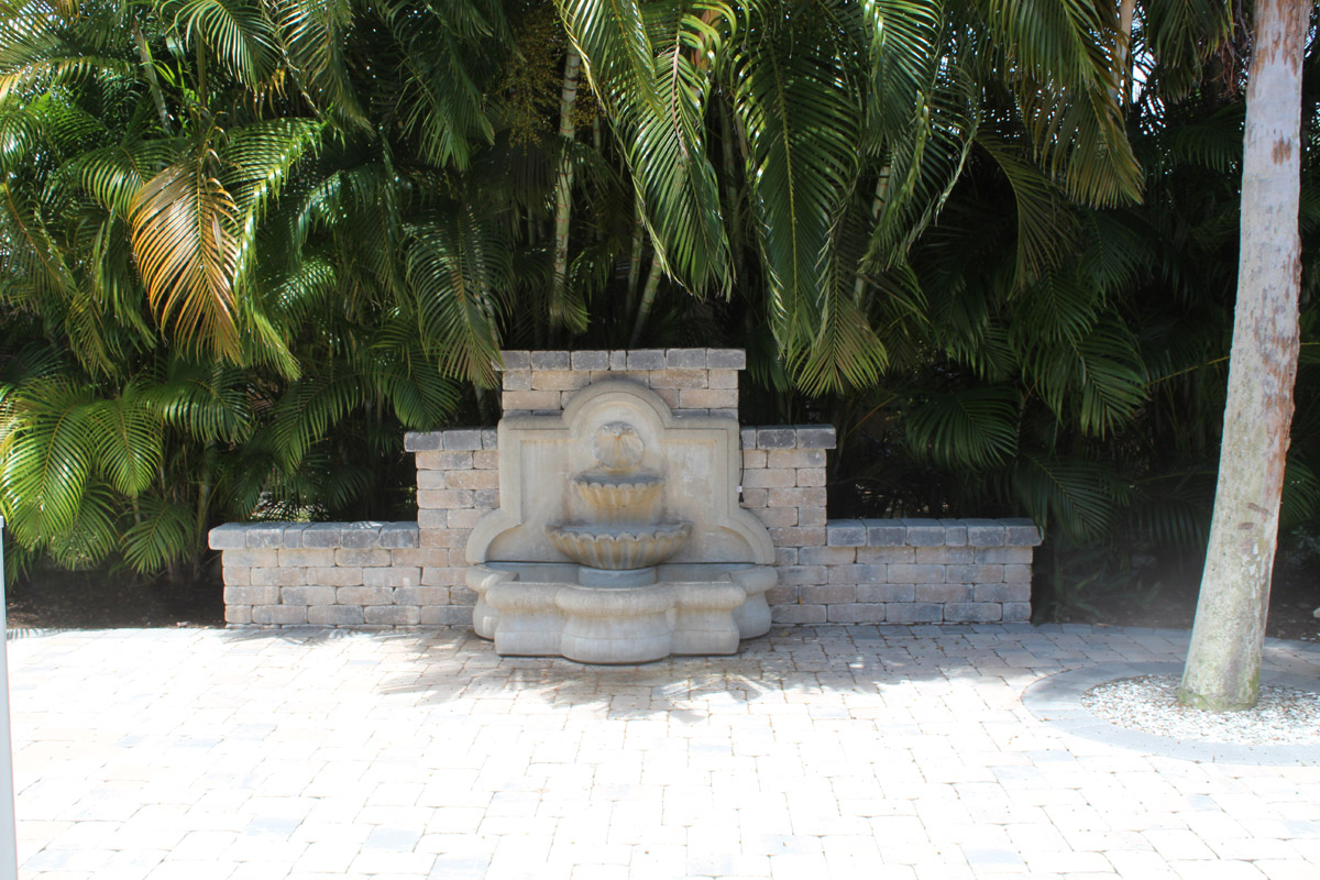 The side patio leads to the back yard decorated by a beautiful fountain.   