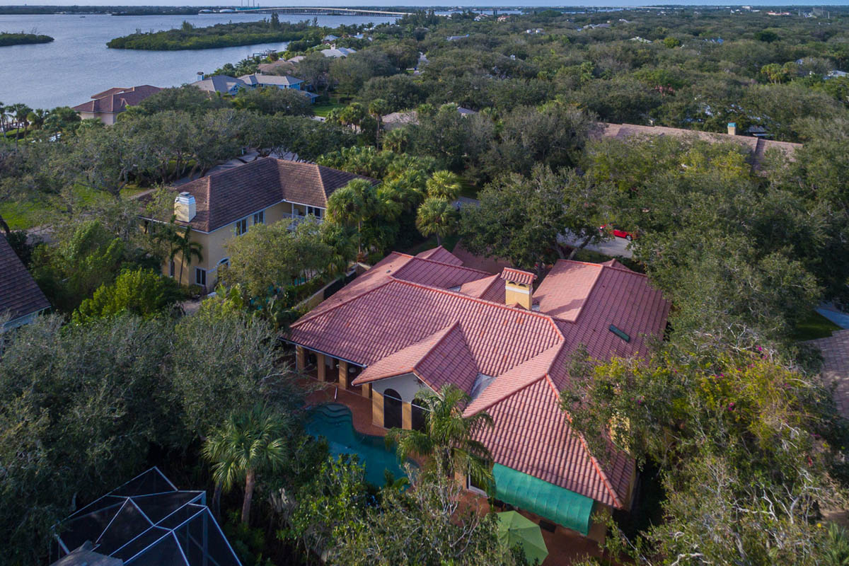 A close up aerial view of the house in Castaway Cove a beautiful community In Vero Beach with mature oaks, steps to the river and granted beach access.