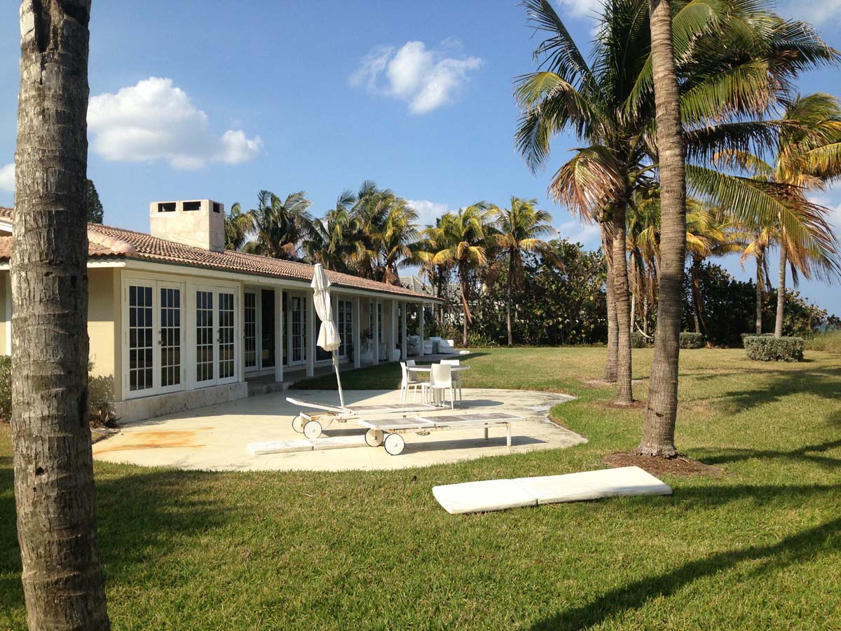 The wide backyard and patio offer several spots to relax and enjoy the ocean breezes under the mature palm trees.        