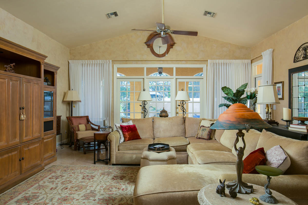 The French doors in the living room open to the covered and screened porch and pool patio area.       