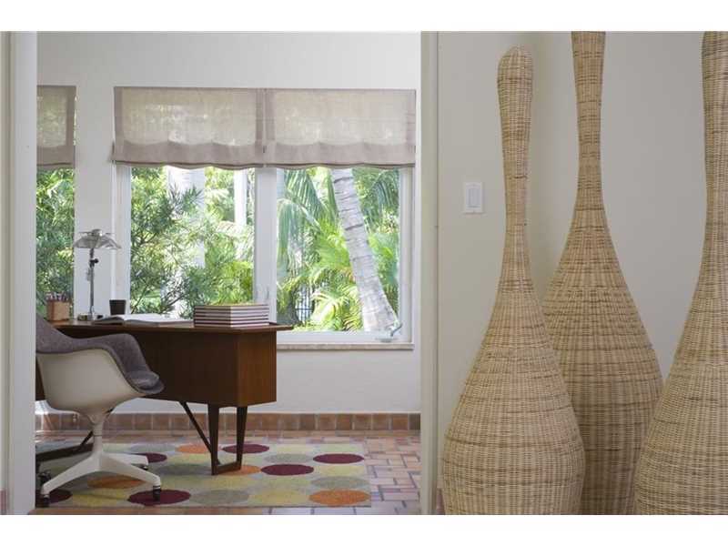 The enclosed porch with Cuban tiles offers beautiful views to the front garden in this Art Deco style villa in South Beach in Miami.